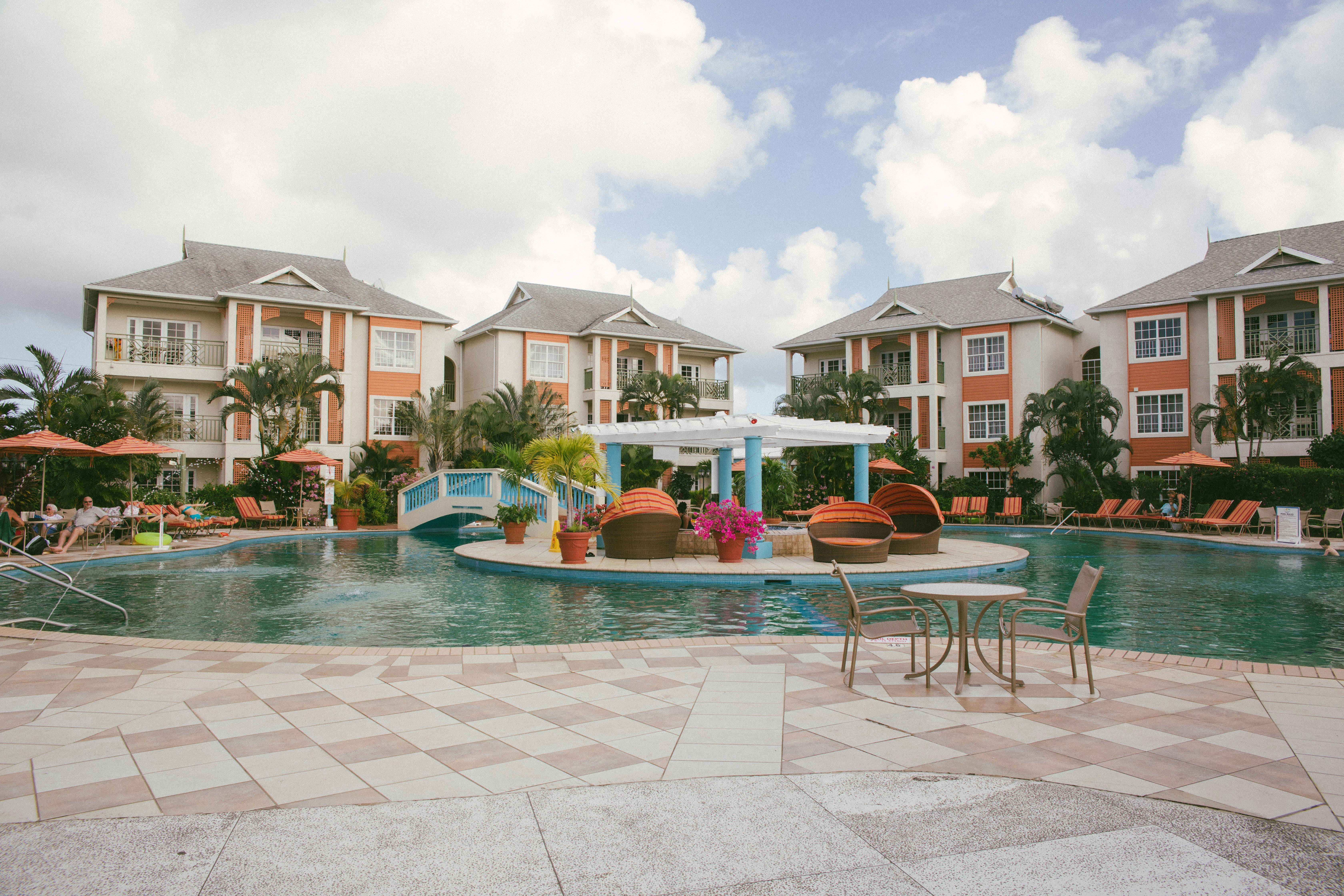 brown and white concrete house near swimming pool during daytime