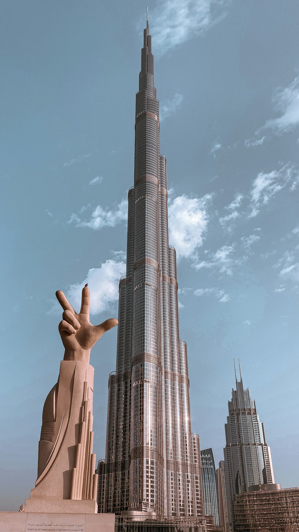 person raising hand near high rise building