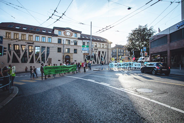A group of activists holding banners and Irish flags during a peaceful environmental protest in a city square.