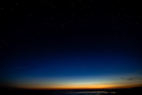 A serene night sky with subtle gold accents reflecting the adonabi brand colors.