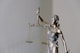 woman in dress holding sword figurine