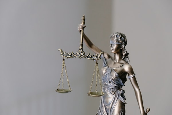 A bronze Lady Justice holding up her scales.