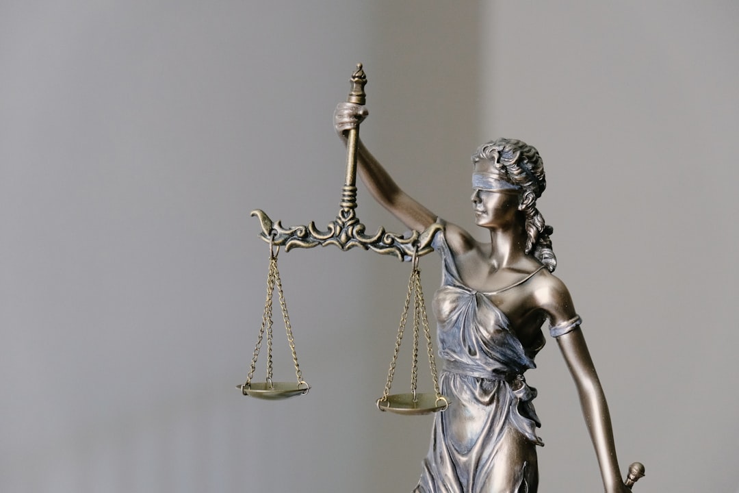 woman in dress holding sword figurine, Lady Justice.