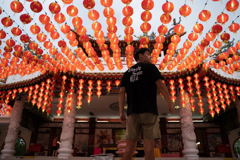 man in black crew neck t-shirt standing near red and yellow balloons