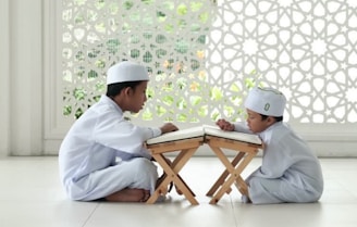 man in white thobe sitting on white floor tiles