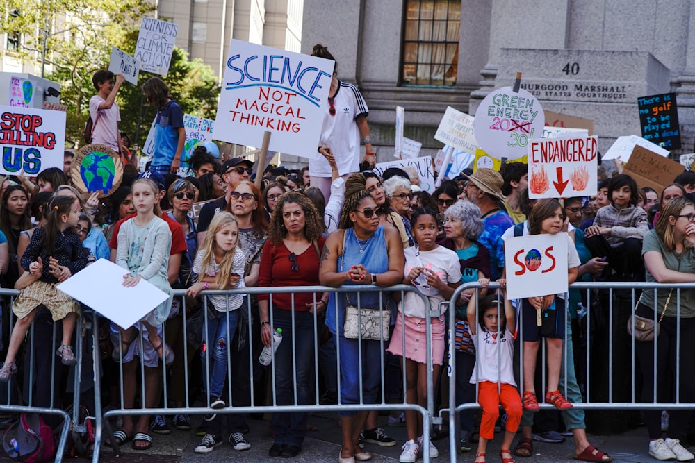 group of people holding white and blue banner