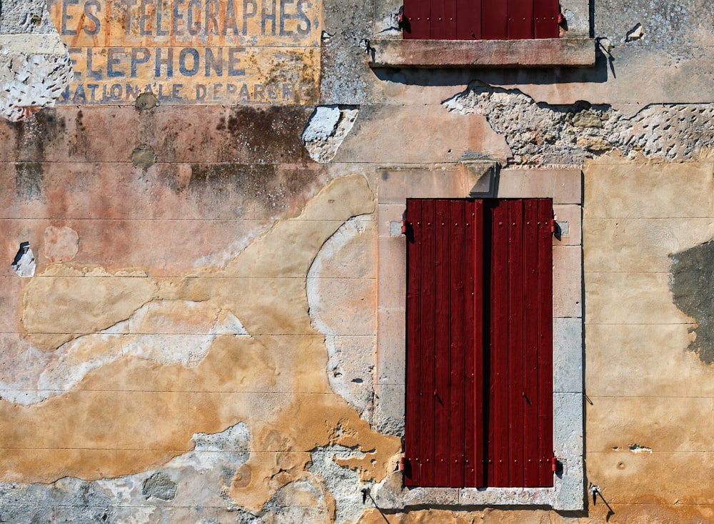 red wooden door on brown brick wall