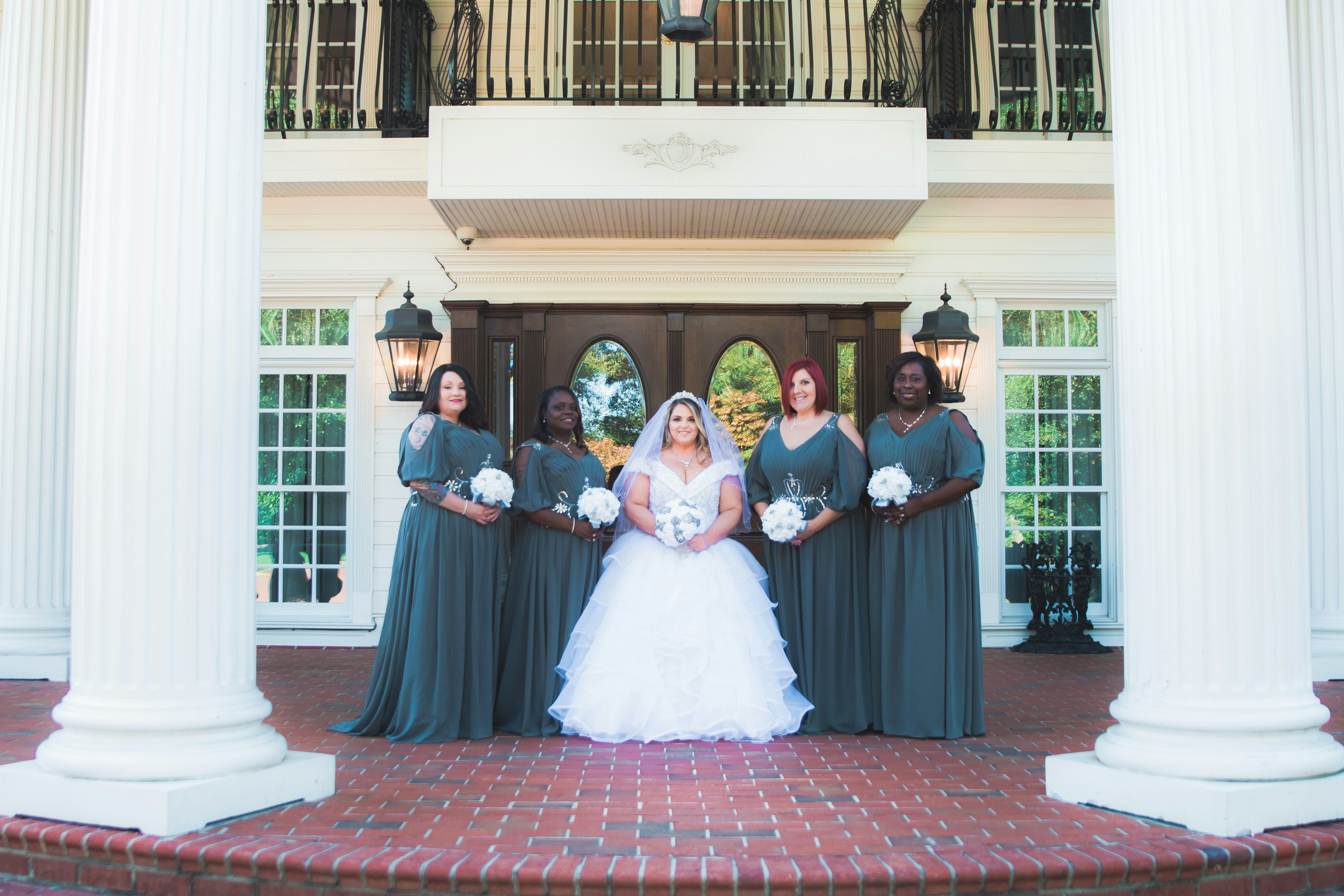 group of women in white dress standing on red brick floor