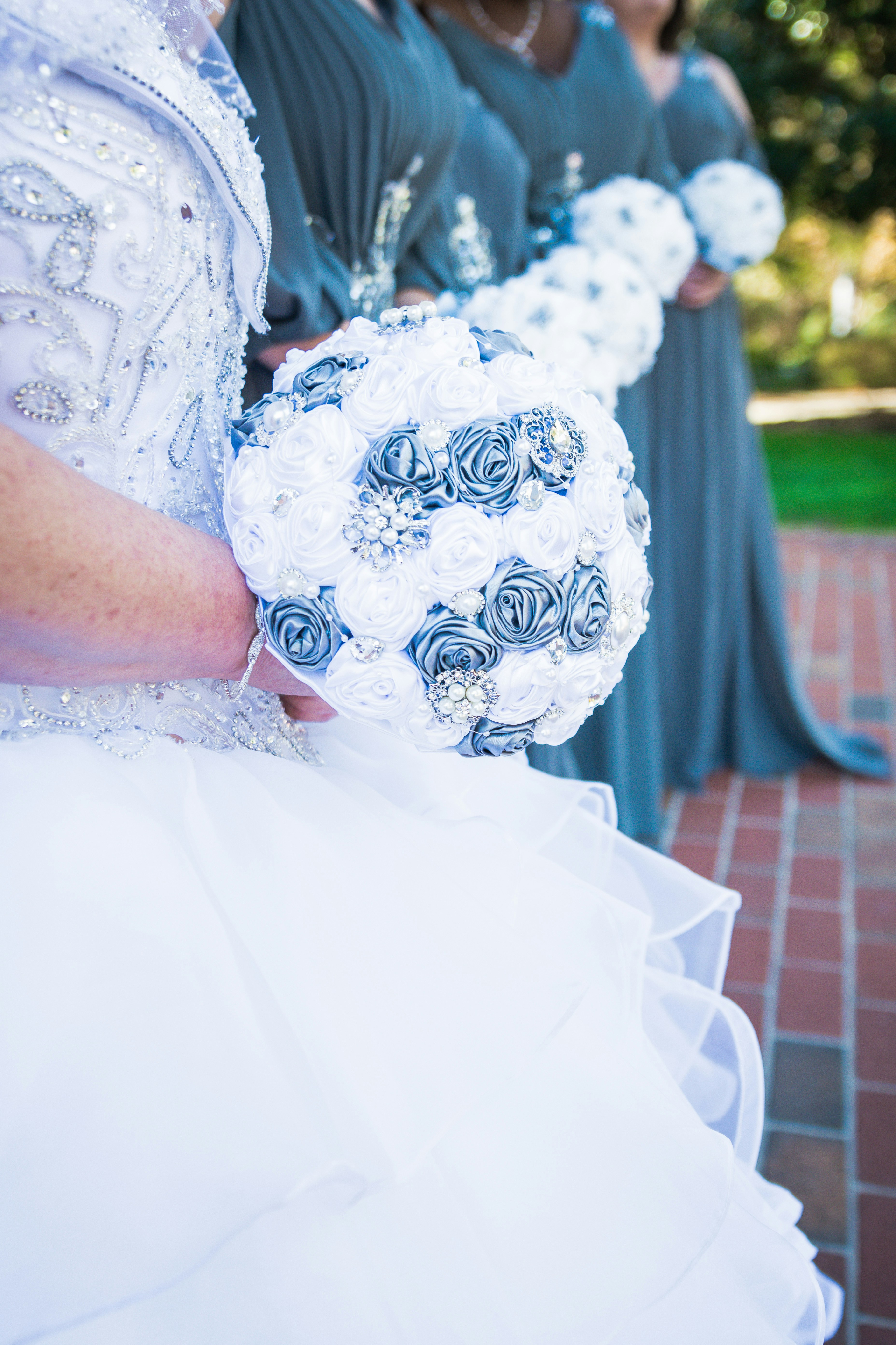 woman in white floral wedding dress holding bouquet of flowers