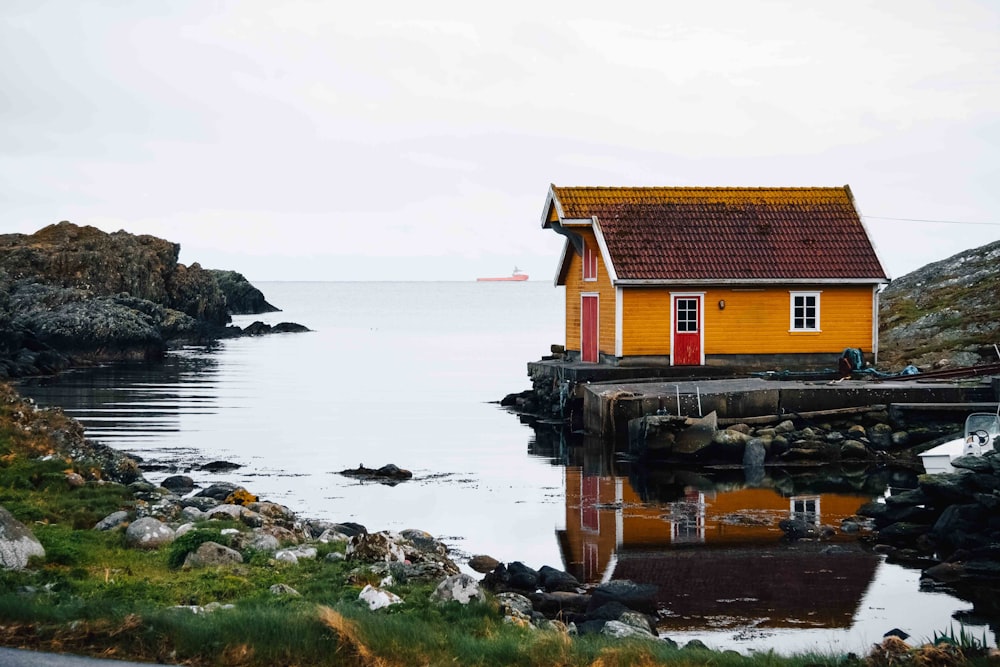 brown and white concrete house near body of water during daytime