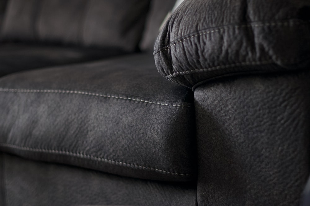 black leather sofa chair with throw pillows