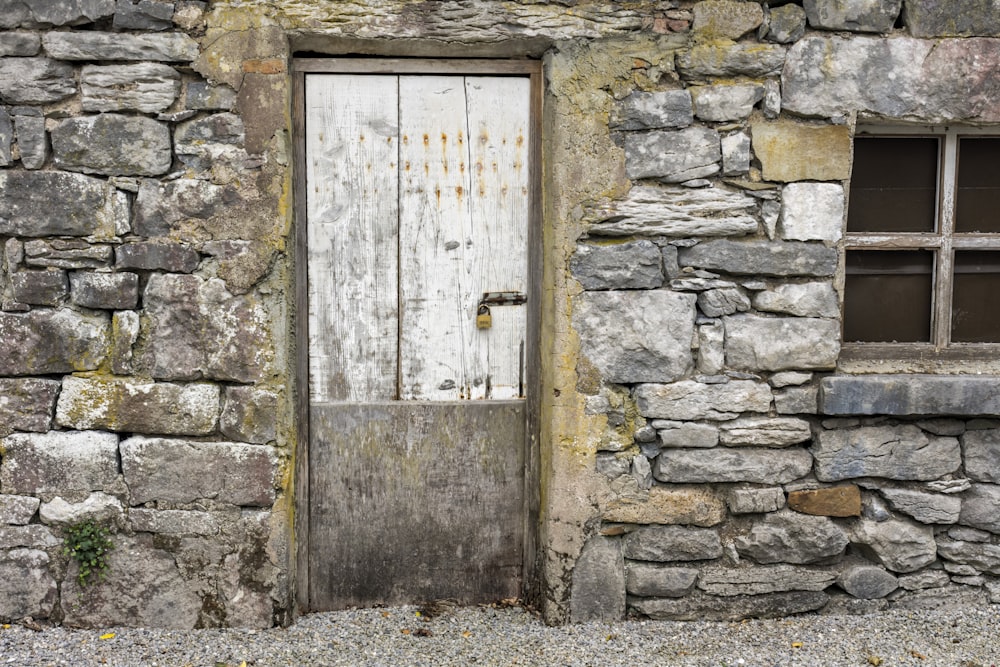 white wooden door on gray brick wall