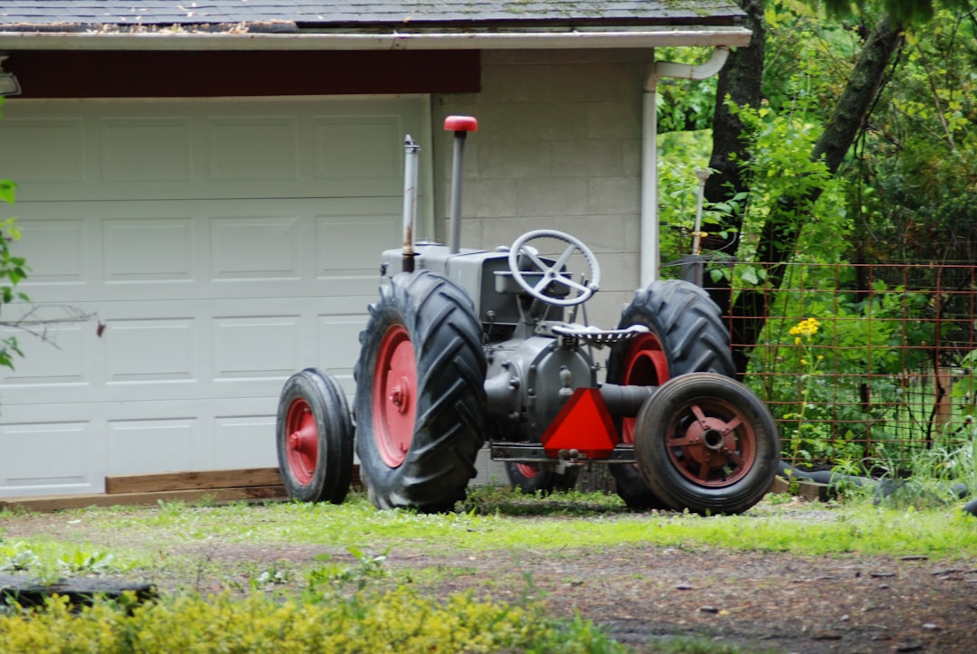 red and black tractor in front of white building