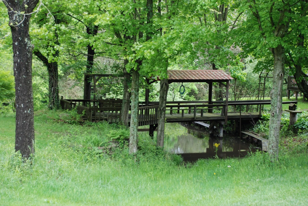 brown wooden house near green trees and river during daytime