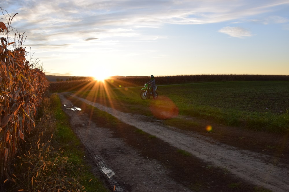 person in green jacket riding bicycle on road during daytime