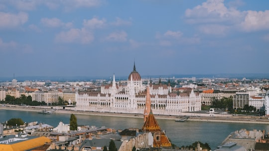white and brown concrete building near body of water during daytime in Fisherman's Bastion Hungary