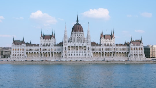 white and brown concrete building near body of water during daytime in Hungarian Parliament Building Hungary