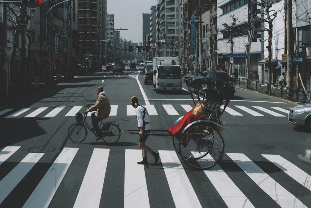 man in white t-shirt and black shorts riding bicycle on road during daytime