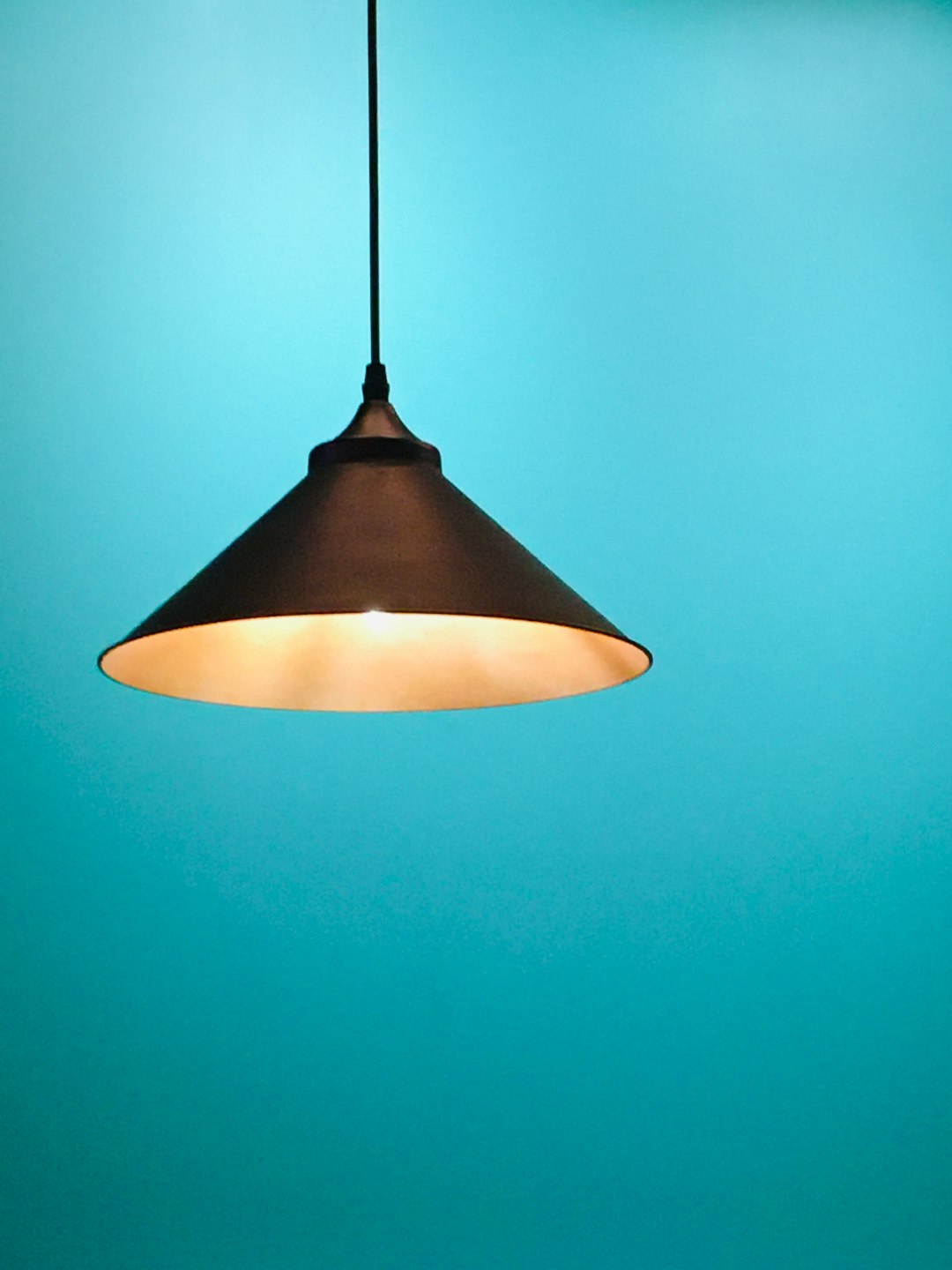  black pendant lamp turned on in room lamp