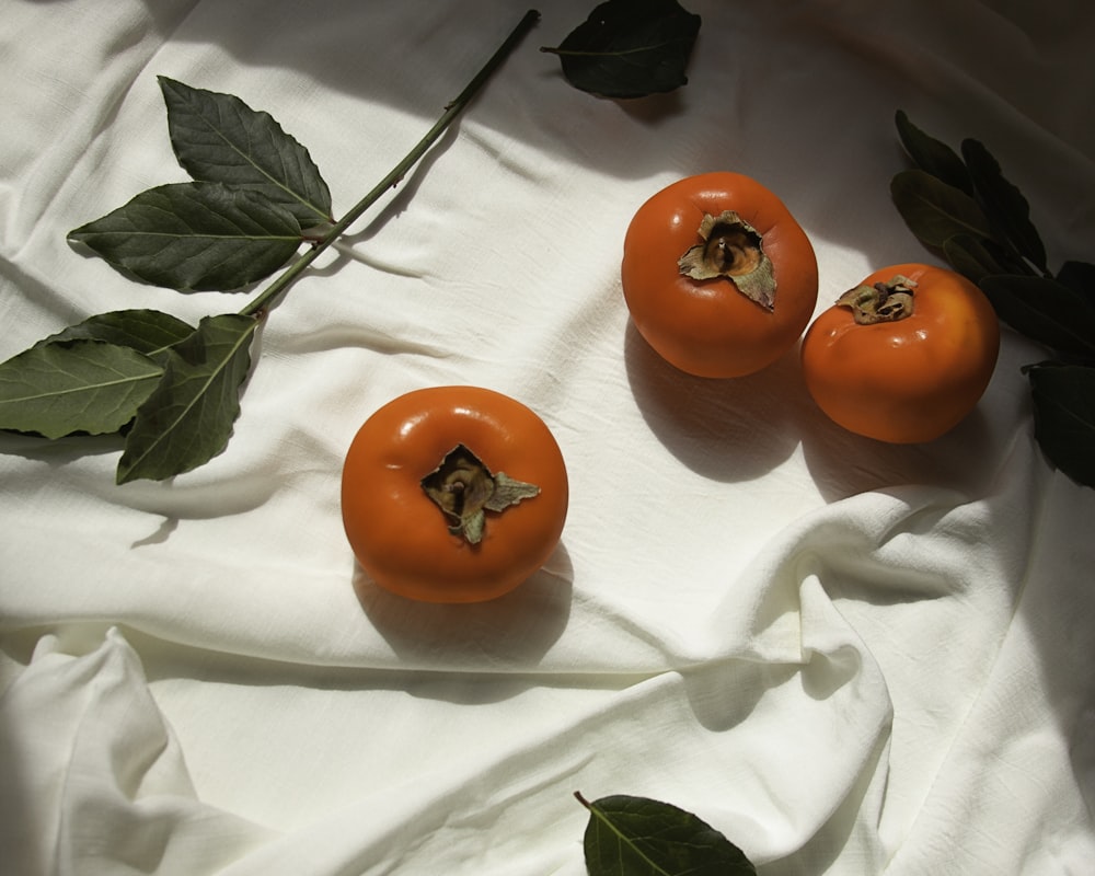 3 red tomato on white textile