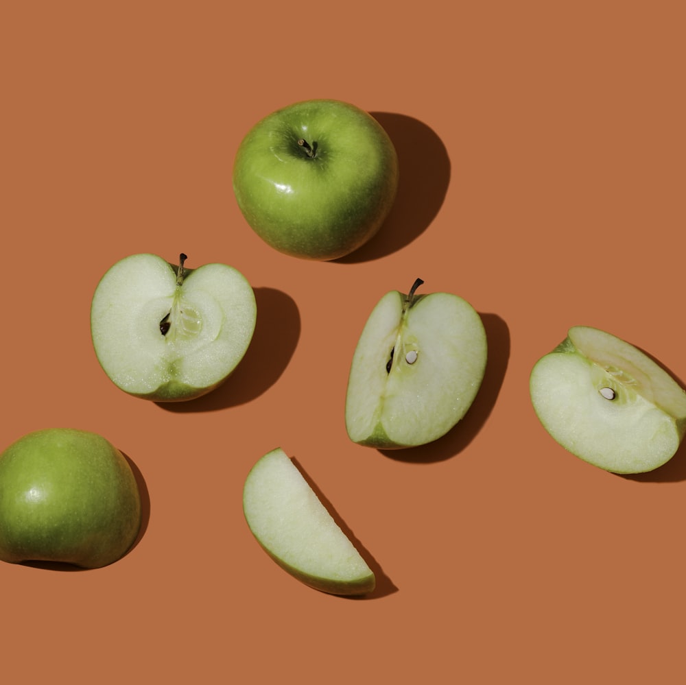 fruta de manzana verde sobre superficie rosa