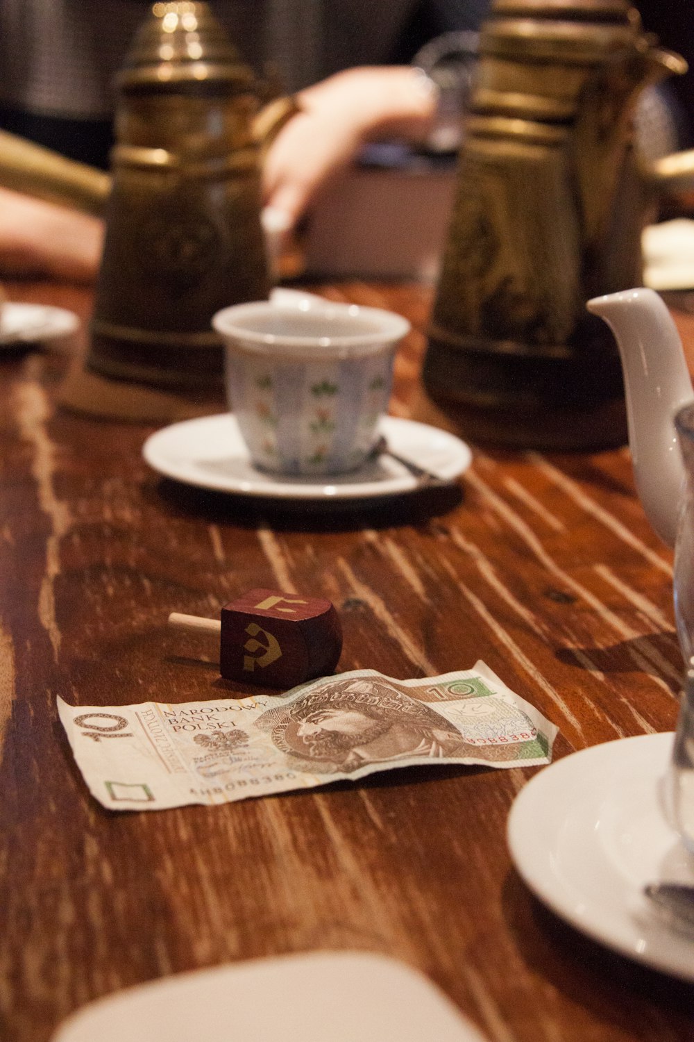 20 banknote beside white ceramic mug on brown wooden table