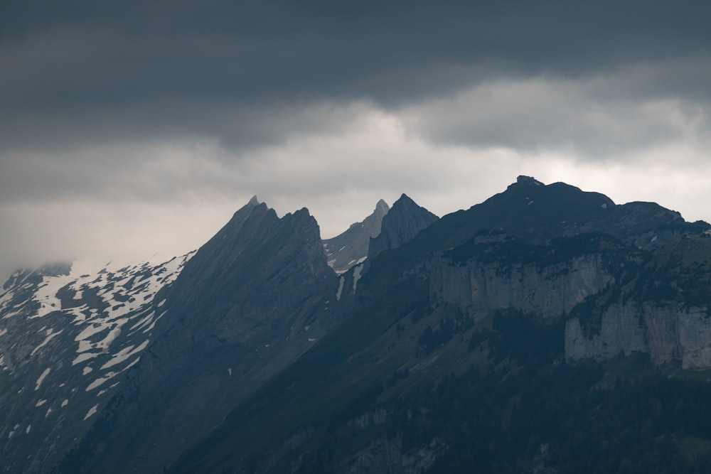 black and white mountains under white clouds