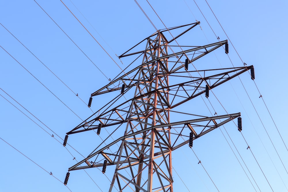 Torres eléctricas marrones y grises bajo el cielo azul durante el día