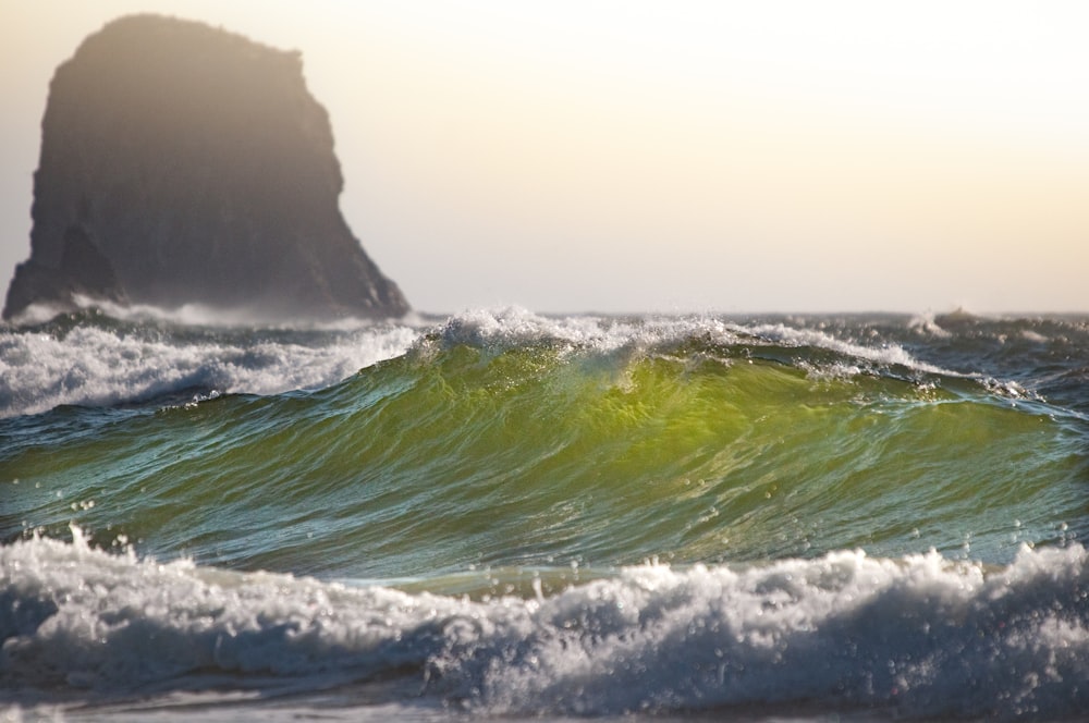 green sea water near black rock formation during daytime