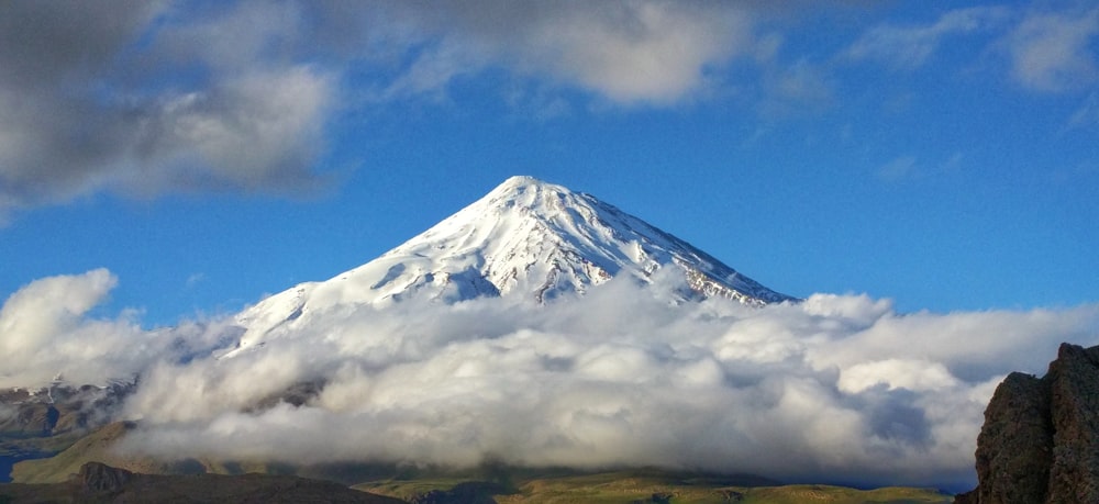 white clouds over snow covered mountain