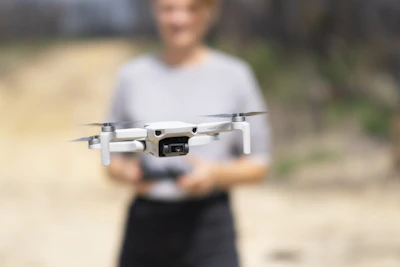 man in gray crew neck t-shirt holding gray and black drone