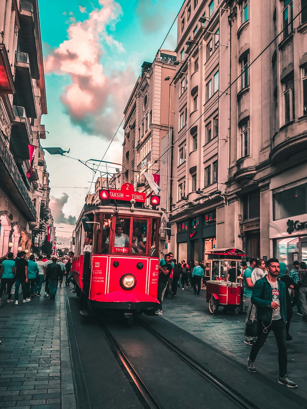 red tram on the street during daytime