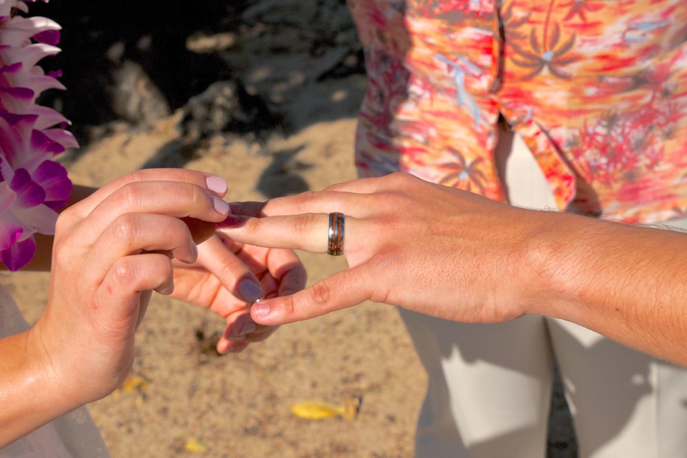 person wearing silver ring with red manicure