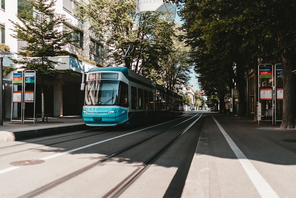 blue and white tram on road during daytime