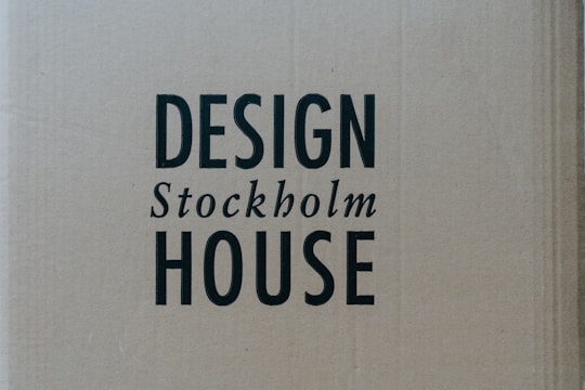 A cardboard background with the words 'DESIGN Stockholm HOUSE' printed in bold black letters.