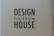 A cardboard background with the words 'DESIGN Stockholm HOUSE' printed in bold black letters.
