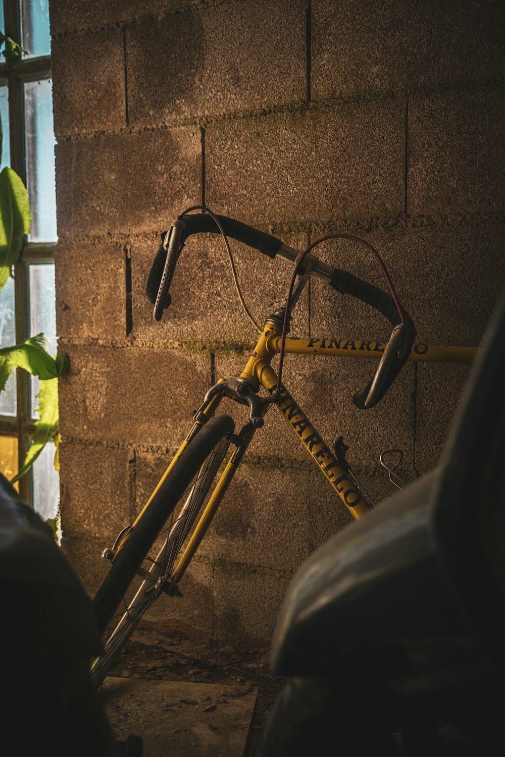 black bicycle leaning on brown wall