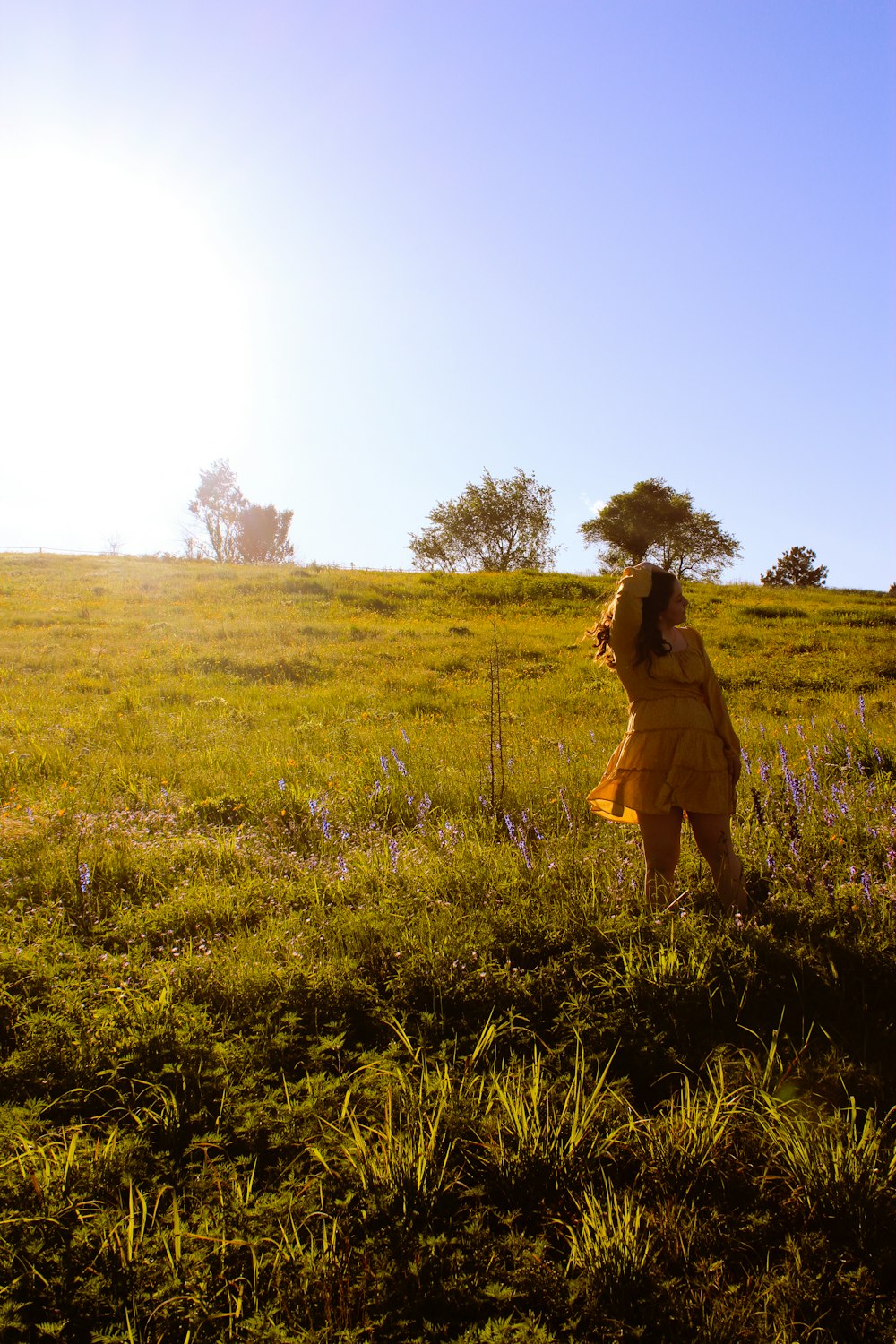 woman in yellow dress standing on green grass field during daytime