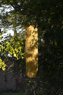 Close-up of a floral yard banner fluttering gently in a sunny garden.