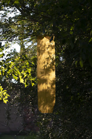 Close-up of a floral yard banner fluttering gently in a sunny garden.