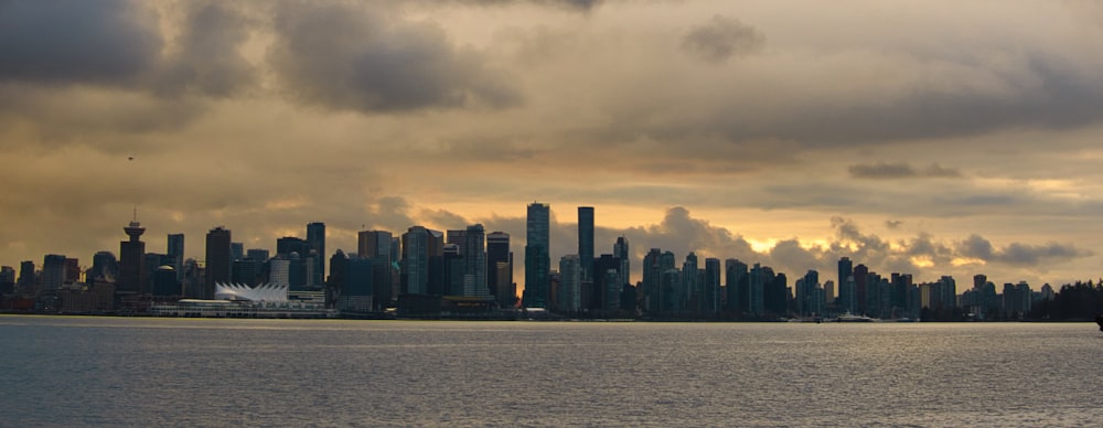 city skyline across body of water during sunset