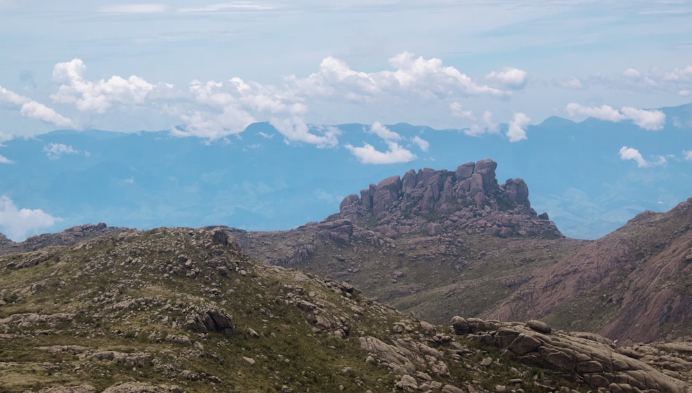 montagne verdi e marroni sotto nuvole bianche e cielo blu durante il giorno