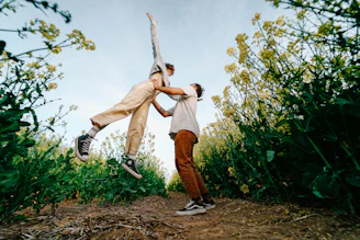 man in brown pants and black shoes standing on brown grass field during daytime