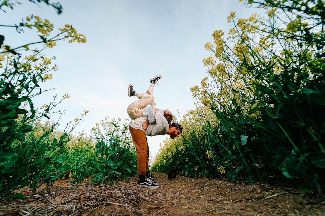 man in white dress shirt carrying baby in white dress during daytime