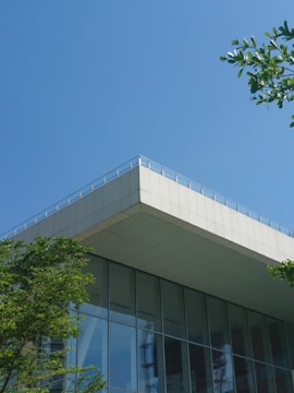 A sustainable building surrounded by greenery under a clear sky.