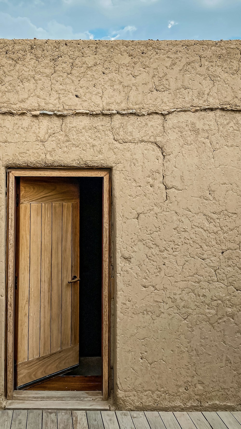 Porta di legno marrone su parete di cemento bianco