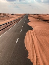 black asphalt road in the middle of desert