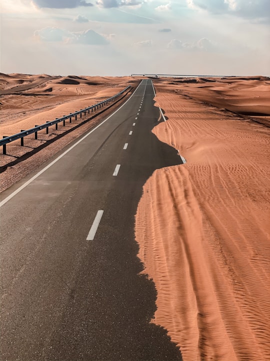 black asphalt road in the middle of desert in Al Ain United Arab Emirates