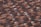 A detailed close-up view of a roof with rows of overlapping terracotta tiles. The tiles have a mix of brown and dark brown shades, giving them a weathered and slightly textured appearance.