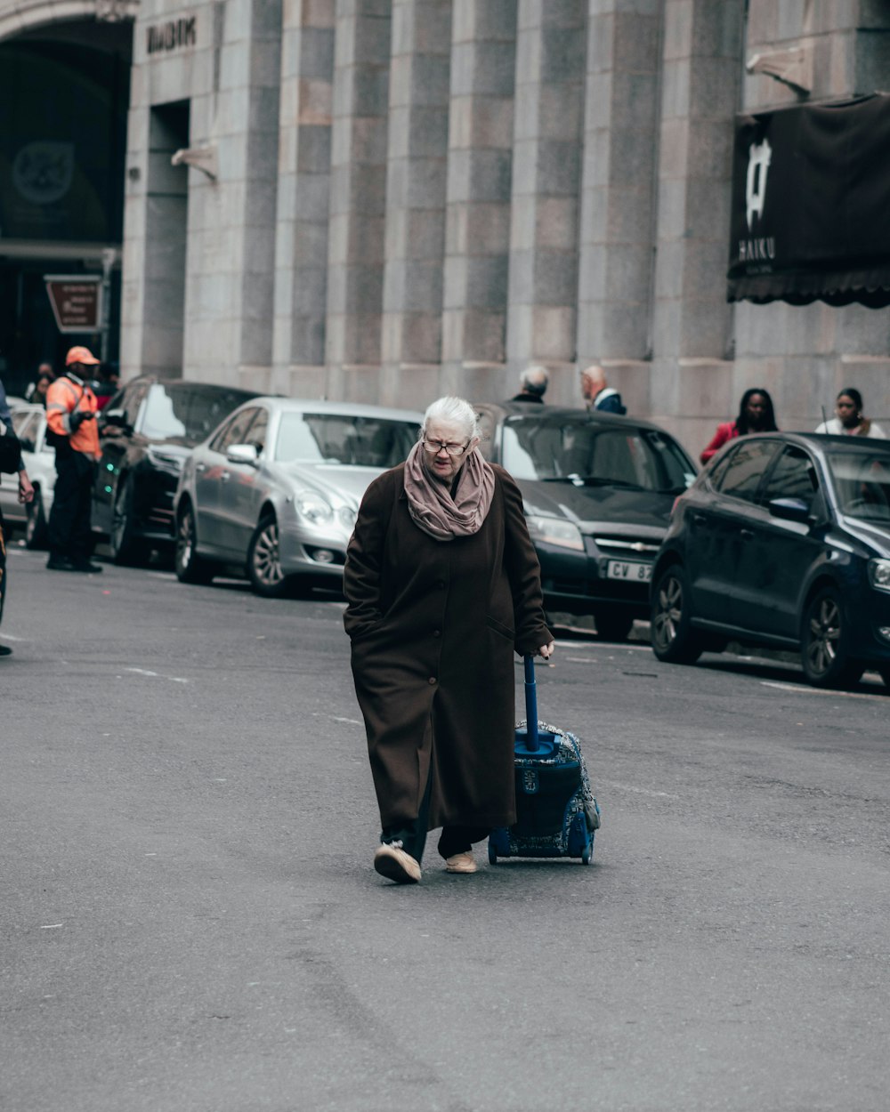 donna in vestito nero in piedi sulla strada durante il giorno